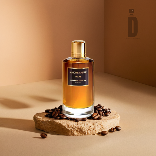 A bottle of Amore Caffe 120ml EDP by Mancera sits gracefully on a stone slab, surrounded by coffee beans and delicate notes of vanilla. The warm brown backdrop beautifully complements this fragrant combination, encapsulating the essence of a cozy café ambiance.