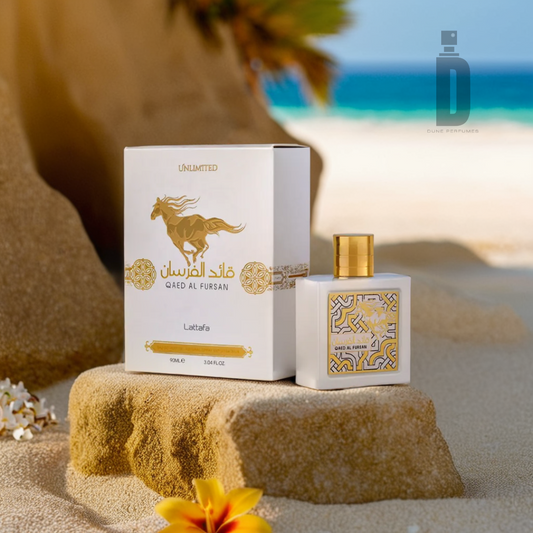 The Qaed Al Fursan Unlimited 90ml EDP by Lattafa is elegantly presented in a bottle and box set on a sandy beach amidst tropical flowers with a whisper of coconut; the serene blue ocean and sky serve as the backdrop. The sophisticated packaging, featuring an exquisite golden horse design alongside Arabic text, transports you to an exotic fragrance journey.