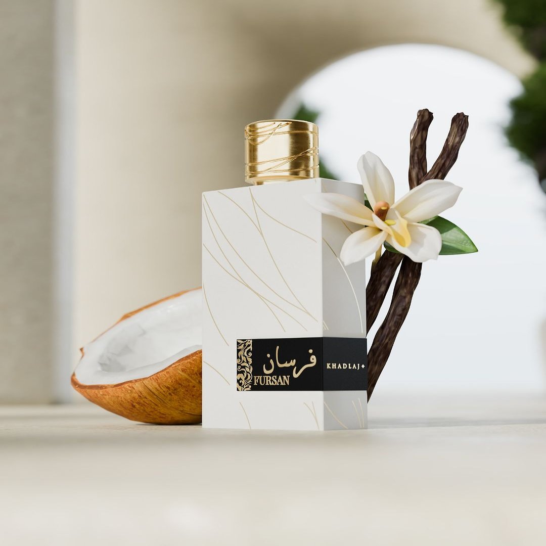 A luxurious bottle of Fursan White 100ml EDP from Khadlaj, adorned with a gold cap, is elegantly positioned next to a halved coconut, vanilla pods, and a white flower. Its captivating vanilla cedarwood scent beautifully complements the backdrop of archways and lush greenery.