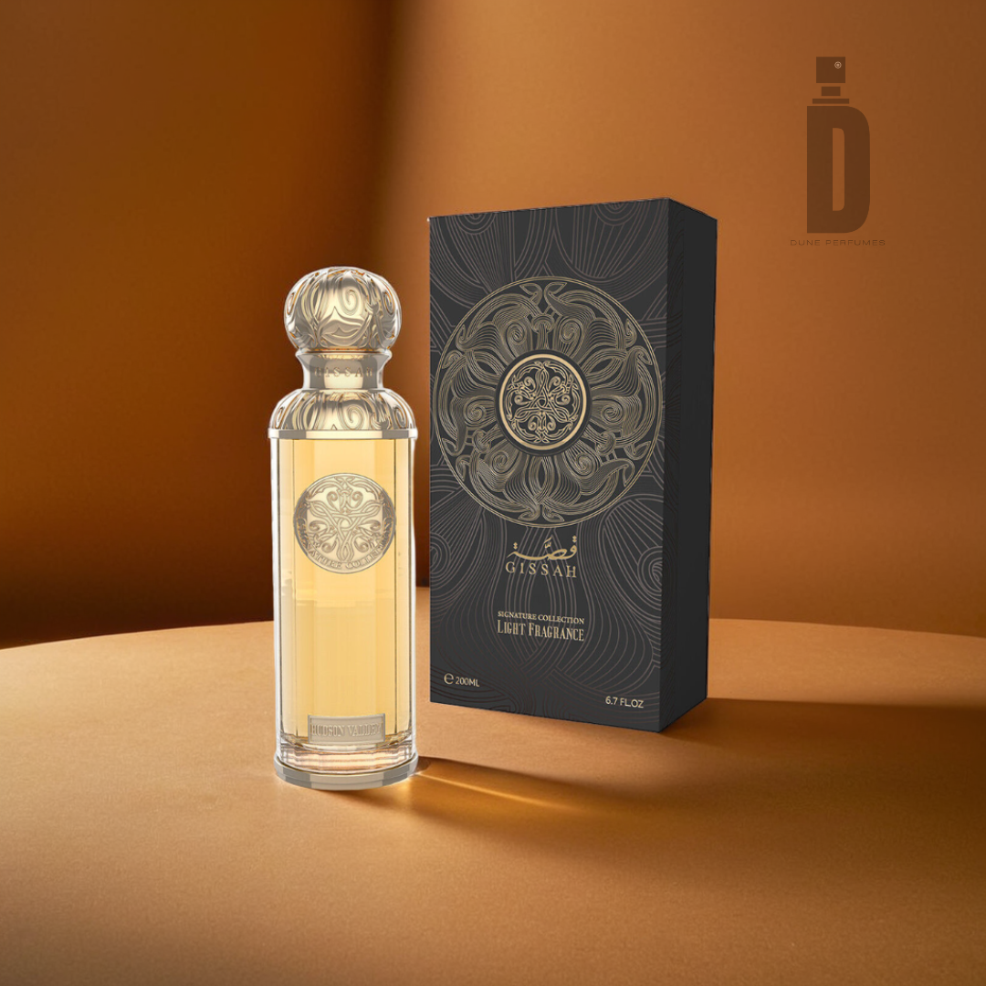 A luxurious bottle of Hudson Valley 200ml EDP - Gissah, featuring an ornate design, is displayed alongside its elegant black and gold packaging against a warm brown background. The transparent bottle holds a golden-hued liquid infused with rose notes, capturing the exquisite charm of a Gissah fragrance.