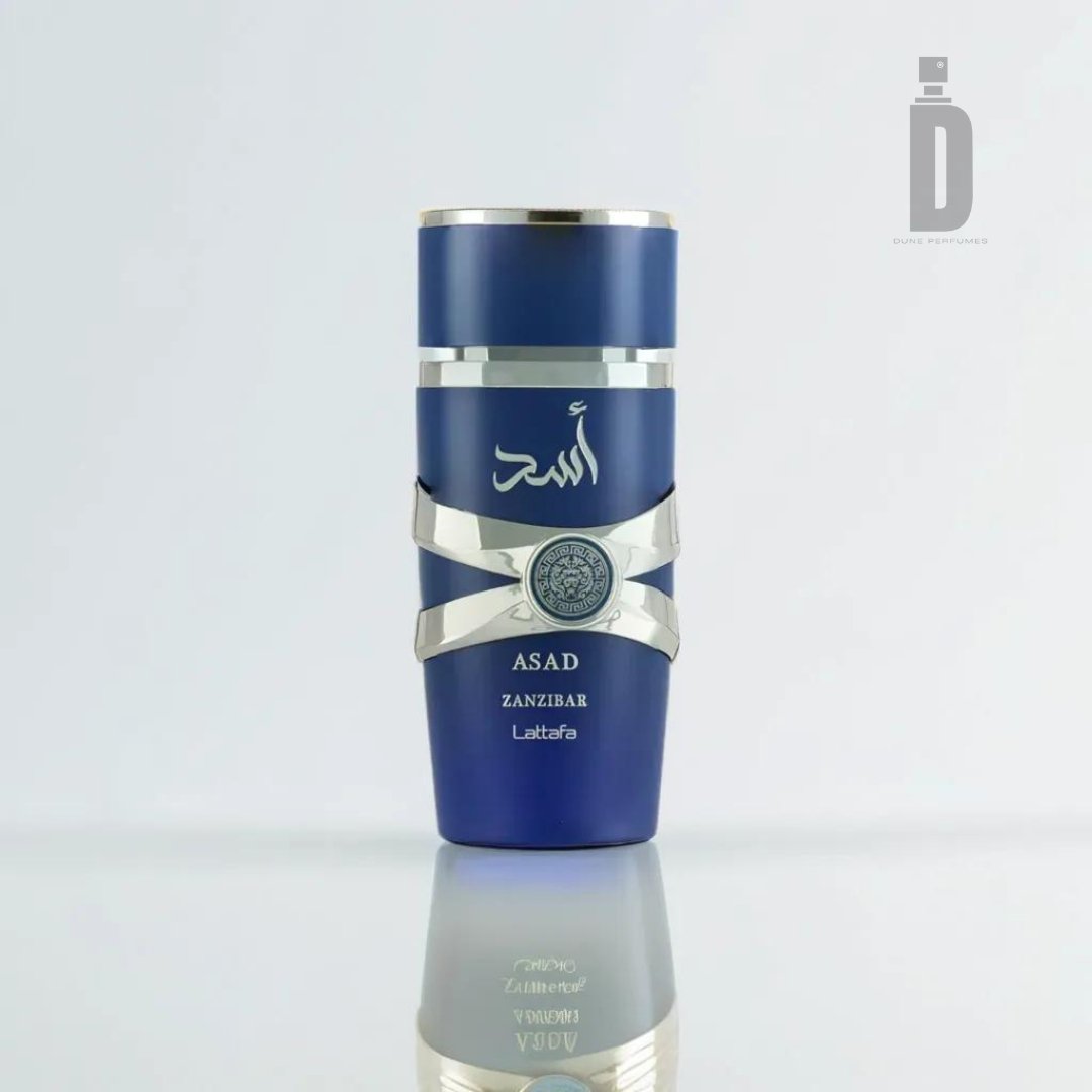 A blue and silver bottle of "Asad Zanzibar 100ml EDP - Lattafa" stands out against a light background. The bottle showcases Arabic script and a decorative circular emblem, exuding an exotic allure. The brand name, Lattafa, is displayed below the Arabic text.