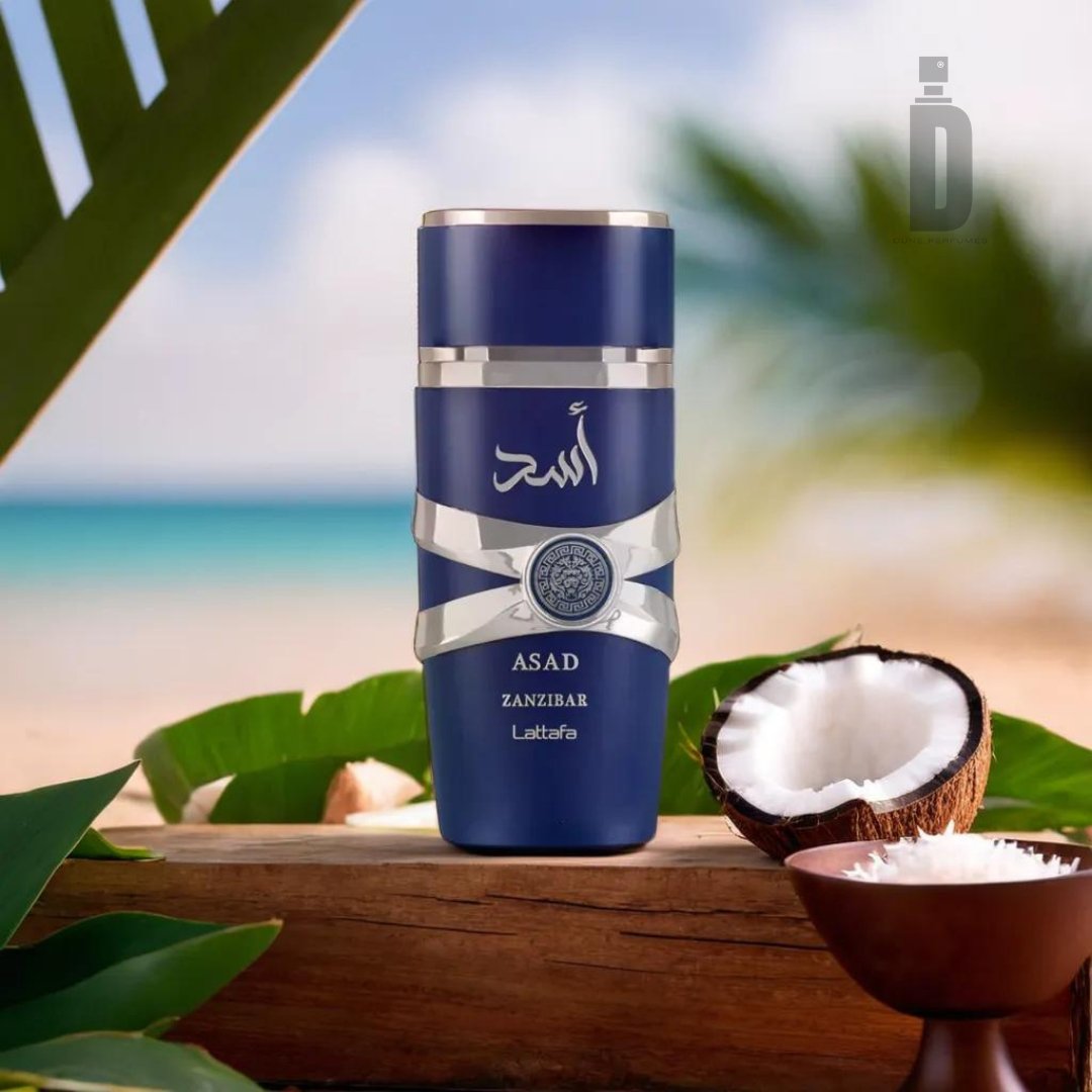 A stylish blue container of Asad Zanzibar 100ml EDP - Lattafa fragrance exudes exotic allure as it rests on a wooden surface surrounded by an open coconut, a white bowl of crystallized substance, and tropical leaves. A serene beach with soft sand and blurred ocean waves forms the perfect backdrop.