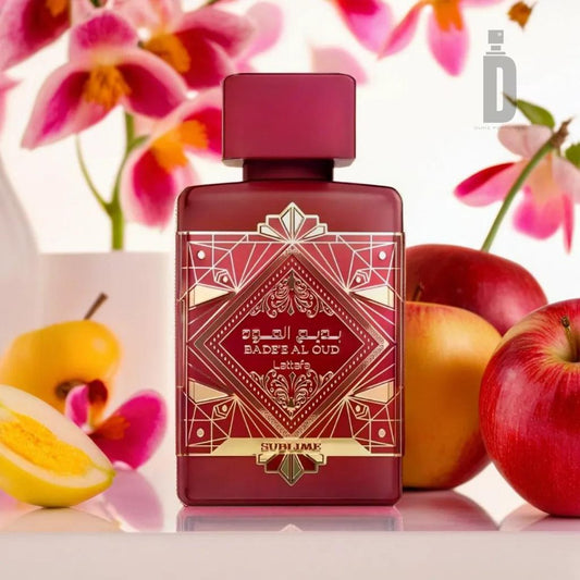 A bottle of Lattafa’s "Badee Al Oud Sublime 100m EDP" stands prominently in the foreground, adorned with an intricate red and gold design. Behind it, an assortment of fruits including apple, cherry, and apricot create a captivating scene against a blurred floral backdrop, evoking a timeless elegance and an enchanting fragrance.