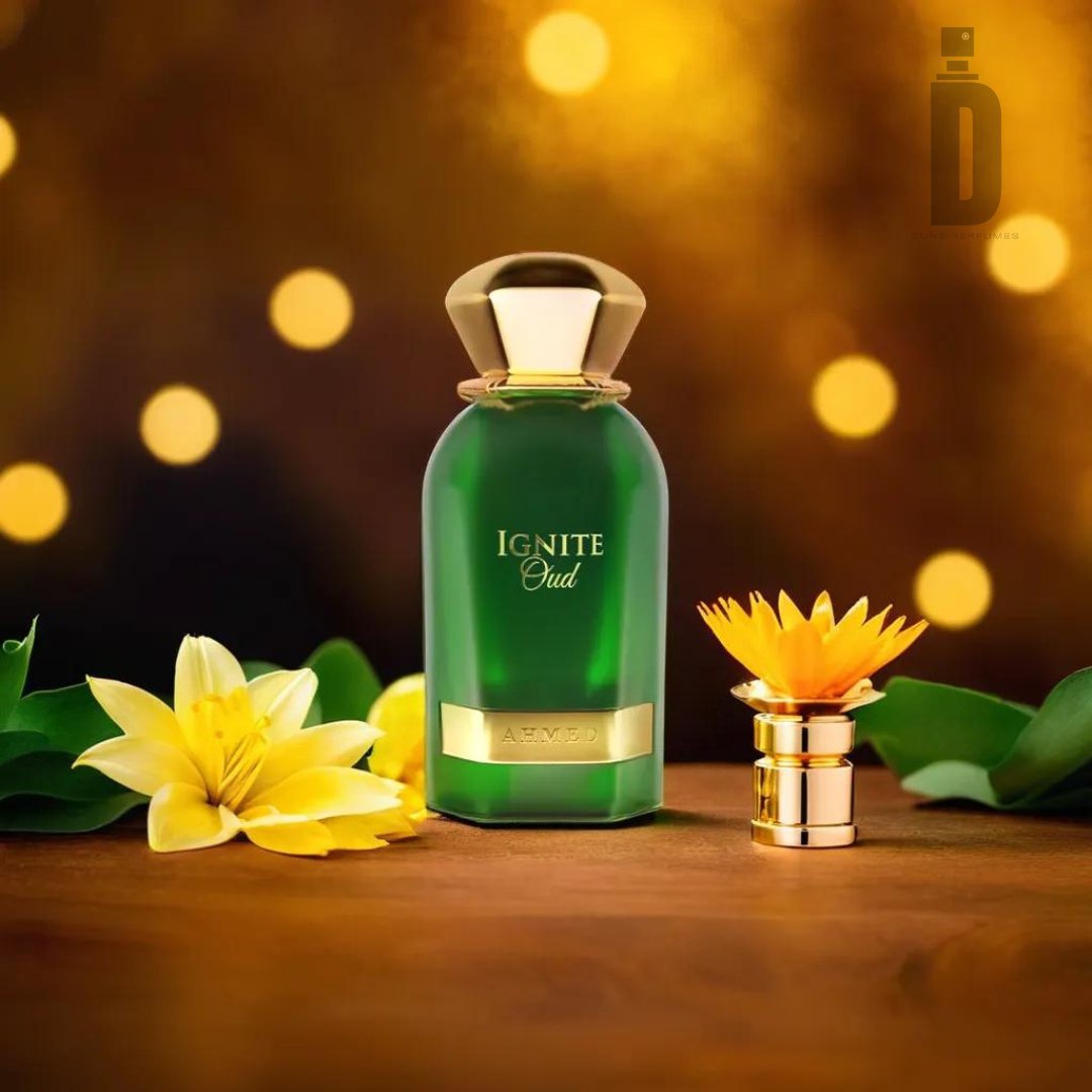 A green bottle of Ignite Oud 60ml EDP by Ahmed Al Maghribi, adorned with a golden cap, stands on a wooden surface, encircled by vibrant yellow flowers and lush green leaves. The background features soft, blurred warm golden bokeh lights that elevate the oud fragrance, creating an elegant and luxurious ambiance.