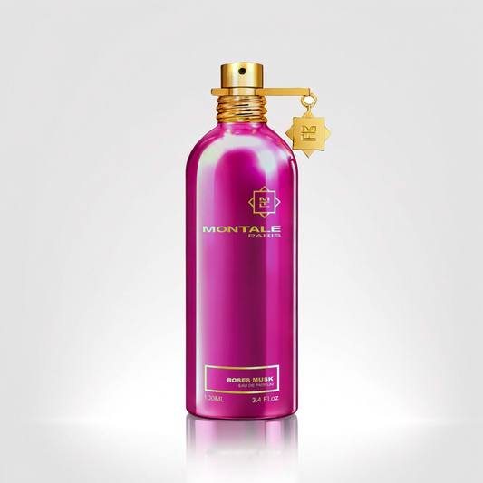 A vibrant pink bottle of Montale's Roses Musk 100ml EDP, enhanced with notes of jasmine, is set against a plain background. The bottle features a shiny gold cap and includes a small gold charm.