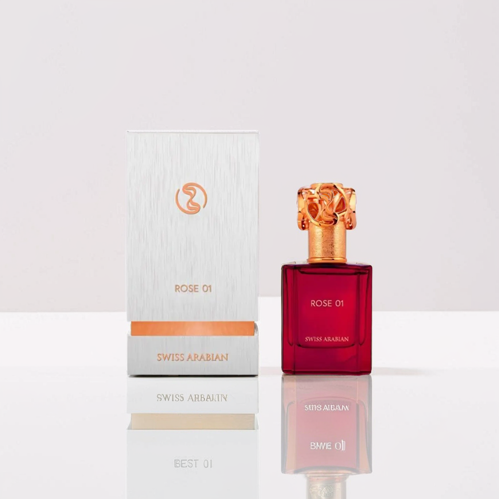 The Swiss Arabian "Rose 01" 50ml perfume features a deep red bottle with an intricate gold cap, accompanied by a matching silver and orange box. This exquisite fragrance embodies the essence of rose against a soft pink and white backdrop.