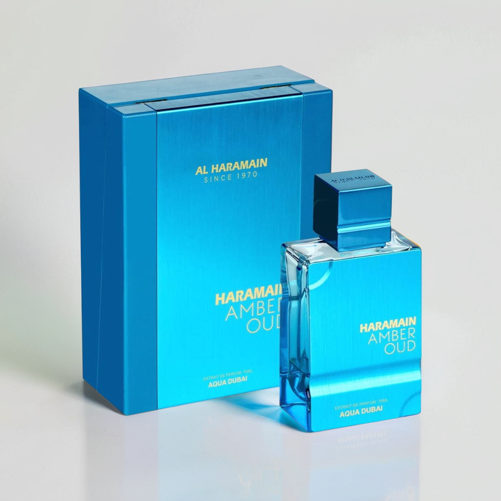 The Al Haramain Amber Oud Aqua Dubai 100ml EDP features a rectangular bottle with a shiny finish, paired with a box that showcases the brand name and "Since 1970" in elegant silver text, offering an alluring Dubai fragrance reminiscent of the Arabian Sea.