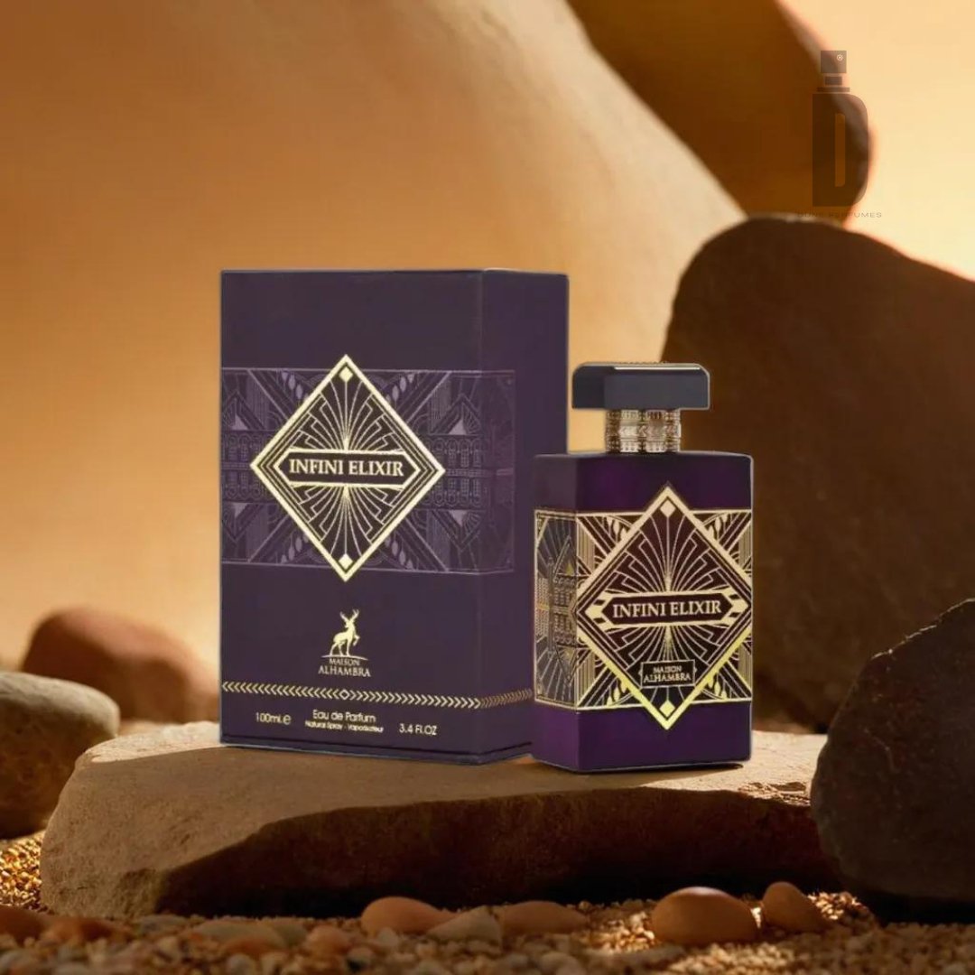 A bottle and its matching box of "Infini Elixir 100ml EDP - Maison Alhambra" by Maison Al Hambra are displayed stylishly against a warm, earthy background with rocks and small pebbles. Both the bottle and box are dark purple adorned with gold and black geometric designs, prominently featuring the name "Infini Elixir," capturing the essence of eternal beauty in its fragrance.