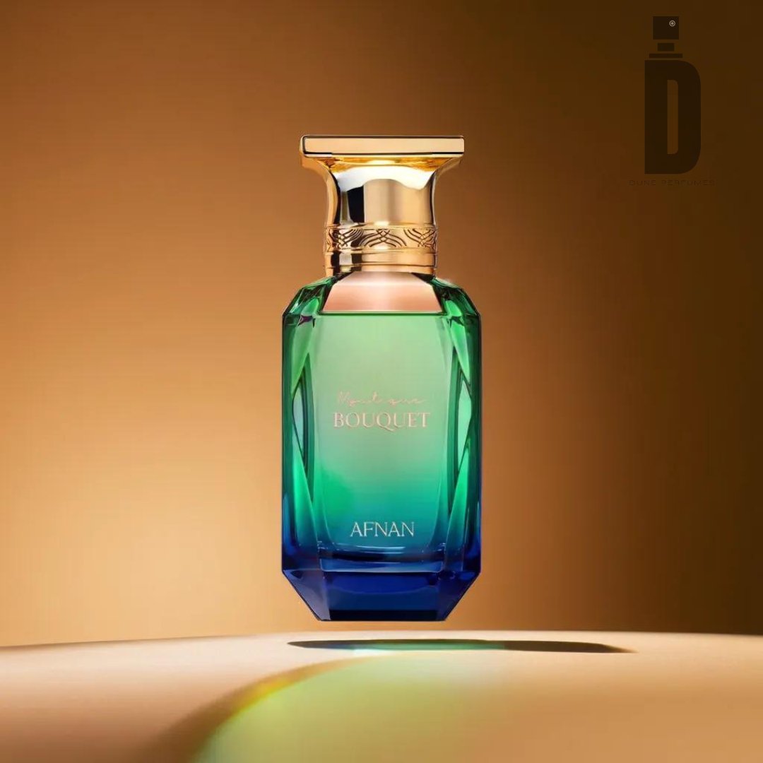 The Mystique Bouquet 80ml EDP by Afnan features a stunning gradient design from green to blue, complemented by an elegant gold cap. The bottle bears the labels "Bouquet" and "Afnan," embodying the essence of fine perfumery. Set against a gradient backdrop of warm golden tones with an interplay of light and shadow, this perfume promises a captivating fragrance experience.